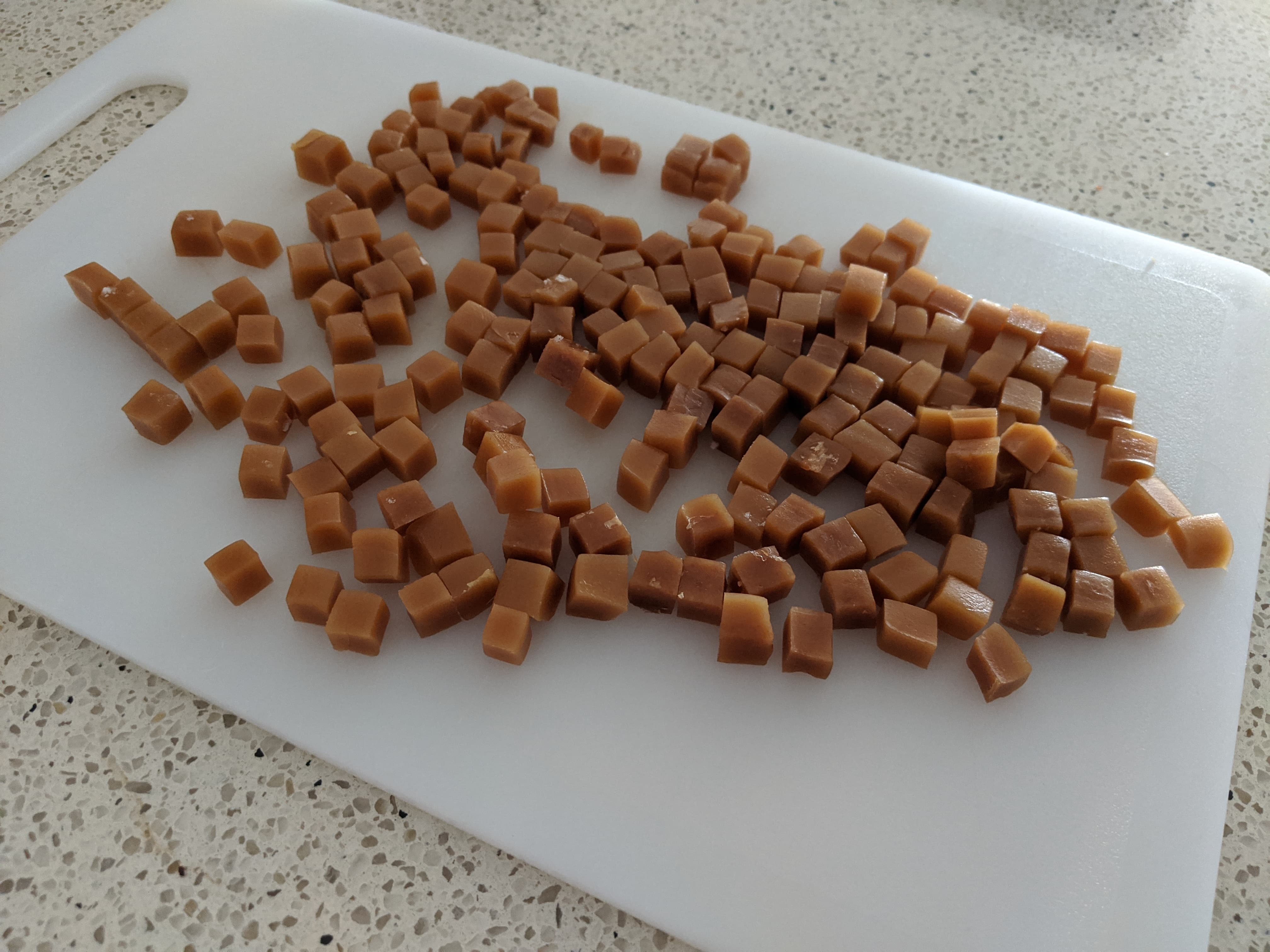 Caramel diced into small cubes on a chopping board