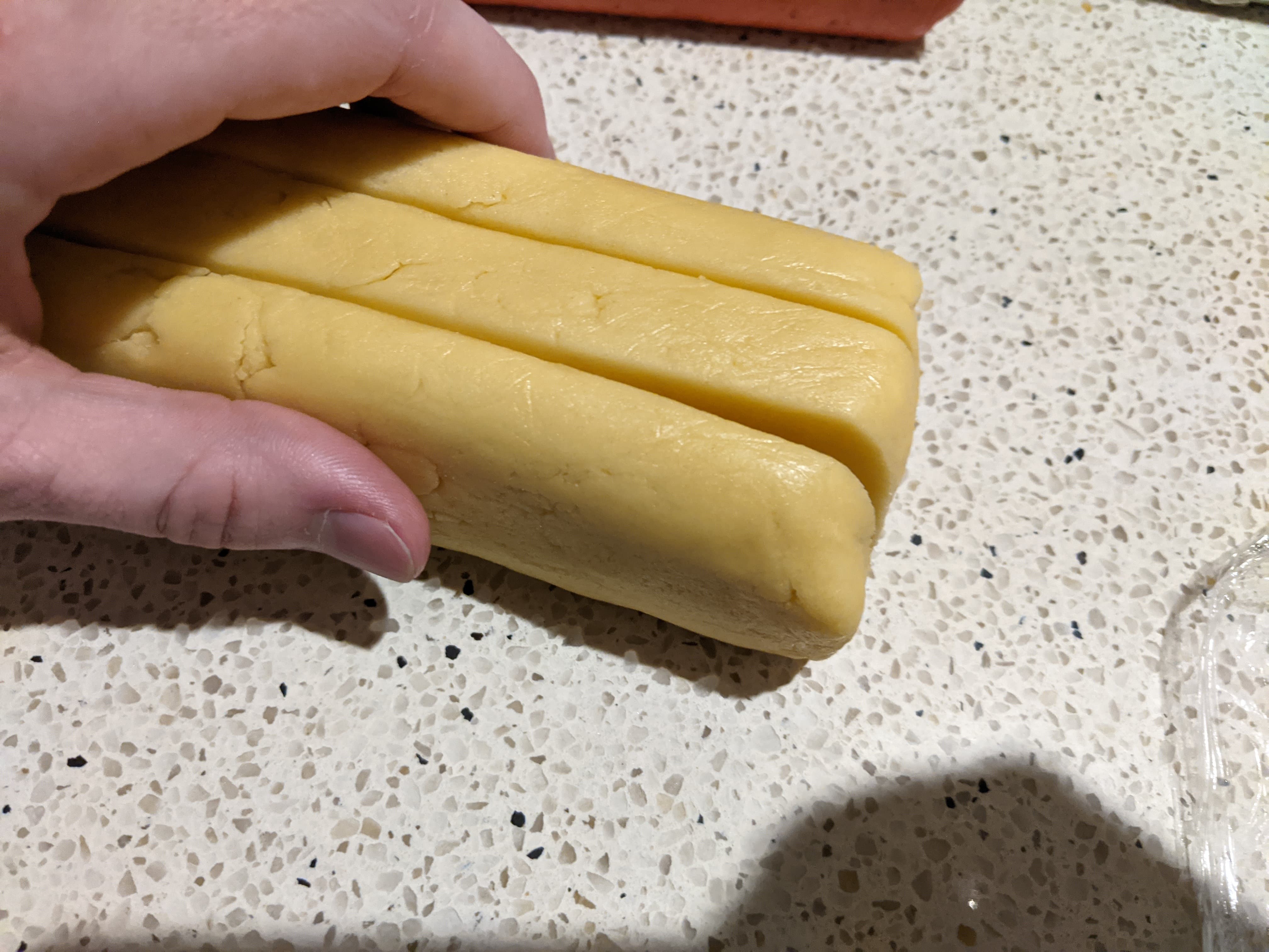 A log of cookie dough sliced lengthways into three equal sections
