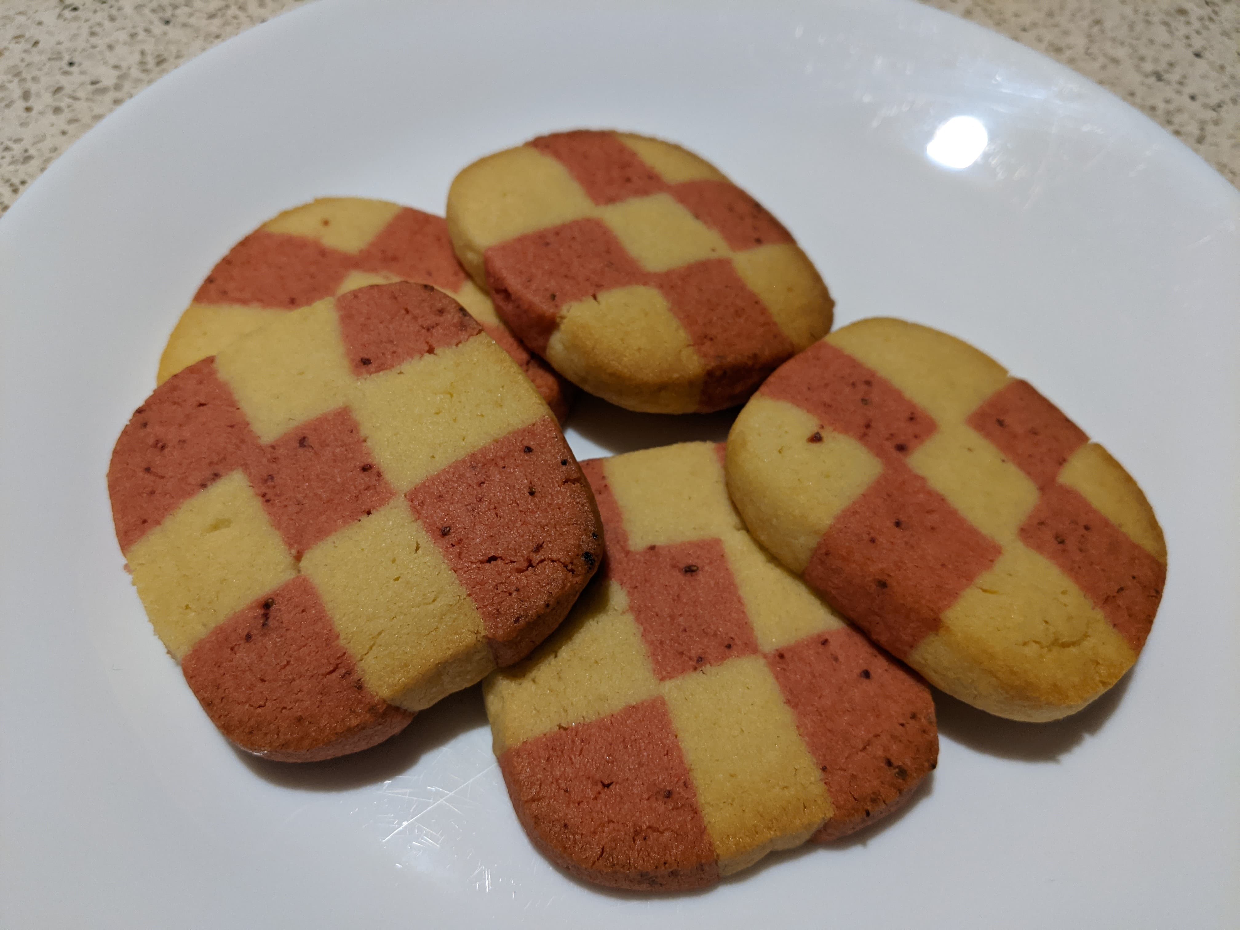 White and pink square-shaped checkerboard cookies on a plate