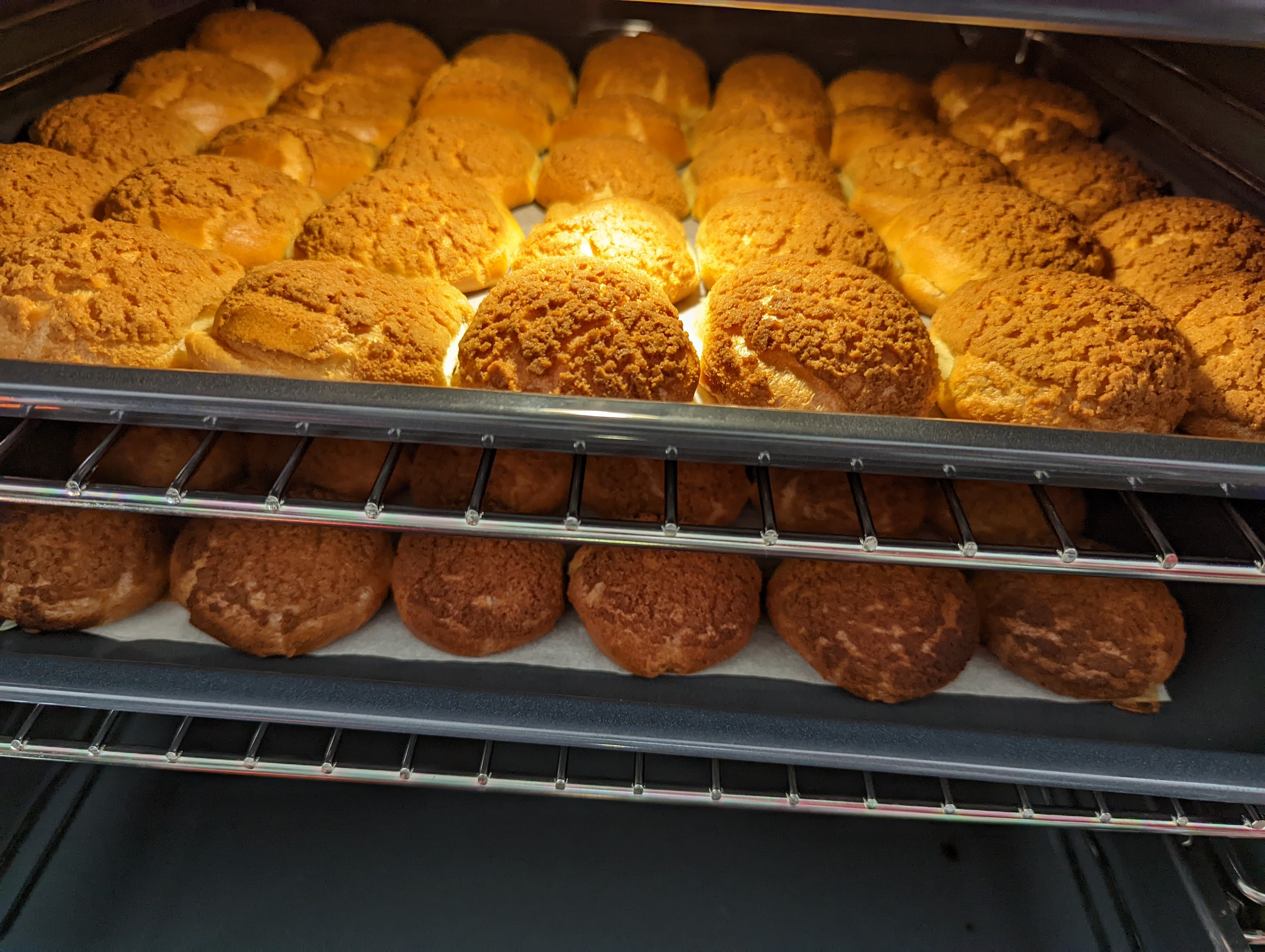Two trays of baked choux pastry inside the oven
