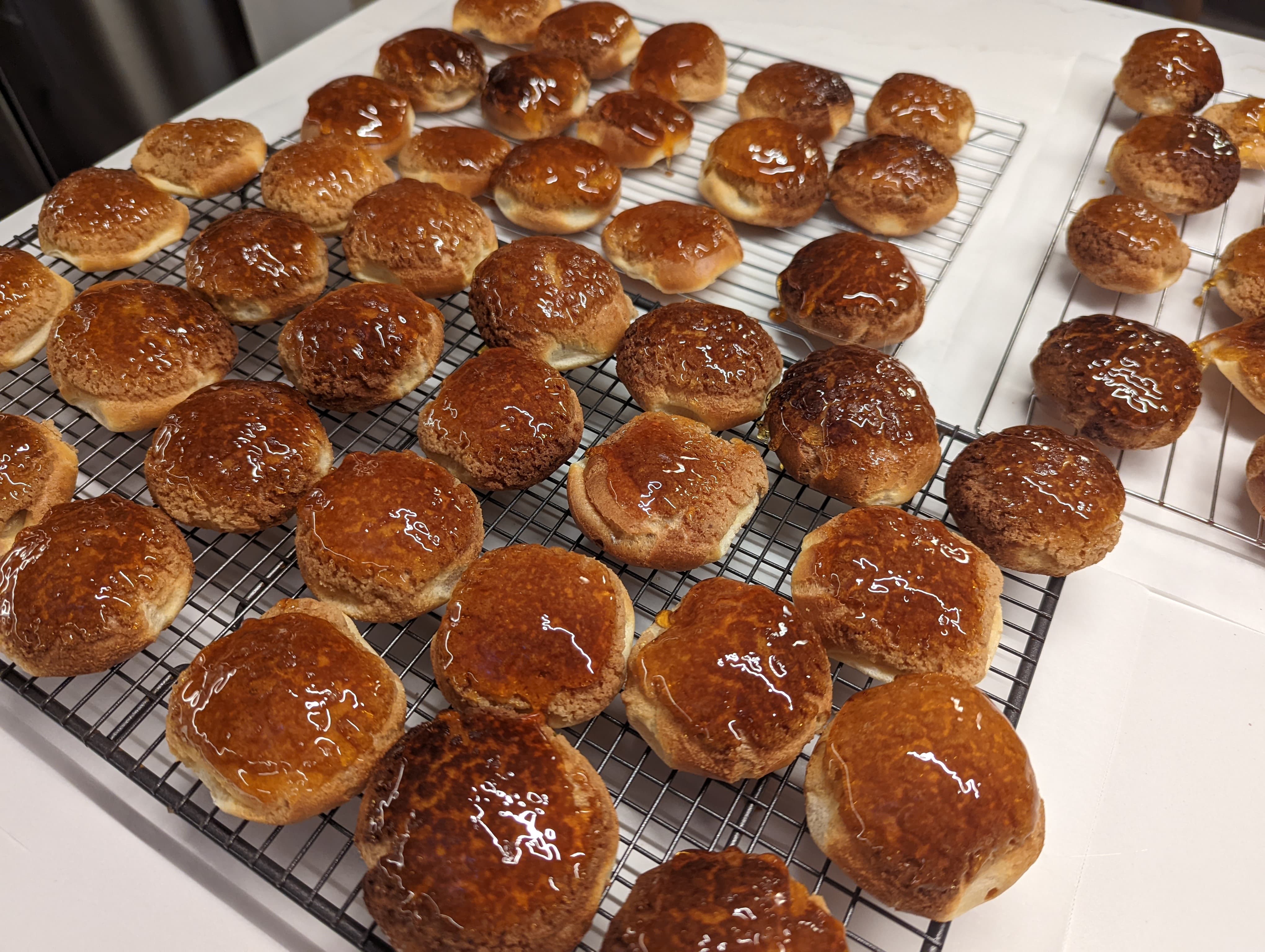 Choux pastries on a wire rack dipped in caramelized sugar
